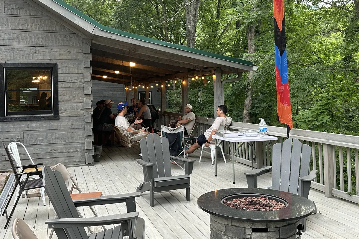 An inviting fire pit area outside, with people gathered under string lights. The scene exudes a friendly and lively atmosphere ideal for storytelling, outdoor games, and making memories as a group.